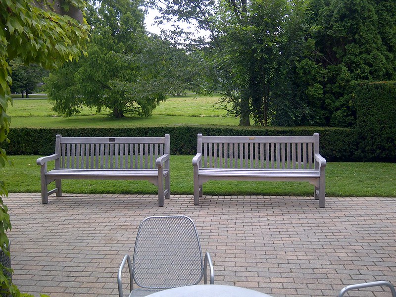 Weathered grey teak benches with straight lines and a slatted back