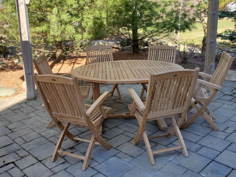 Light teak folding chairs surrounding a round dining table